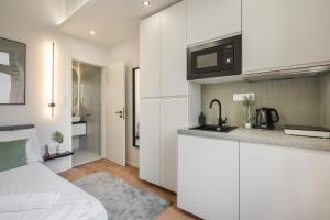 een keuken met witte kasten en een aanrecht bij K27- Boutique Apartments, Best Location, by BQA in Boedapest