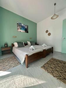 ein Schlafzimmer mit einem großen Bett mit grünen Wänden in der Unterkunft No Name Apartments in Laganas