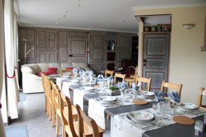 a dining room with a long table and chairs at La Marguerite in Theux