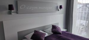 una camera da letto con letto e cuscini viola di Czarna Góra Resort Apartament na Skarpie a Sienna