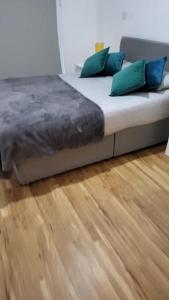 1 cama con almohadas azules y verdes en el suelo de madera en Gillingham One, en Gillingham