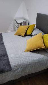 Una cama con almohadas amarillas encima. en Gillingham One, en Gillingham