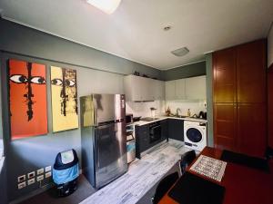 una cucina con frigorifero ed elettrodomestici in acciaio inossidabile di Green Apartment near Marousi Hospitals & OAKA, by PromosHomes a Marousi