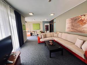 ein Wohnzimmer mit einem Sofa und einem Tisch in der Unterkunft Green Apartment near Marousi Hospitals & OAKA, by PromosHomes in Marousi