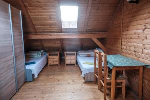 a room with two beds and a table in a cabin at Zajazd Tadeo in Pietrzykowice