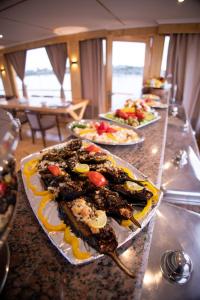 a buffet with several plates of food on a table at Dahabiya Akhnaton Every Monday from Esna to Aswan for 4 Nights in Luxor