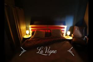 a bedroom with a bed with two lamps on it at La Roche Blanche, maison de bourg pleine de charme in La Roche-Blanche