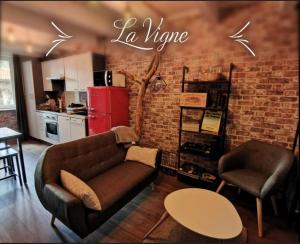 a living room with a couch and a brick wall at La Roche Blanche, maison de bourg pleine de charme in La Roche-Blanche