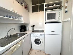 une cuisine blanche avec un lave-linge et un sèche-linge. dans l'établissement 107 - Appartement 2 chambres au Sables-D'Or avec vue mer, à Fréhel 12 autres photos