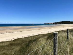 une vue d'une plage avec une clôture dans l'établissement 107 - Appartement 2 chambres au Sables-D'Or avec vue mer, à Fréhel
