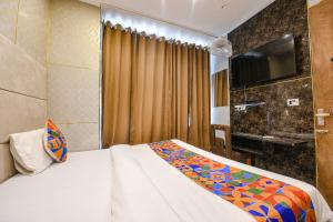 um quarto de hotel com uma cama e uma televisão em FabHotel The Dreams em Chandīgarh