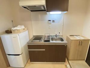 eine kleine Küche mit Spüle und Kühlschrank in der Unterkunft Kyoto Tabisou Kasumi in Kyoto