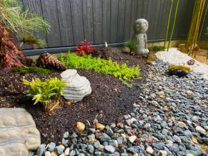 a garden with rocks and a gardener in a yard at Kyoto Tabisou Kasumi in Kyoto
