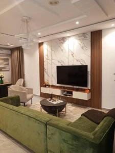 a living room with a green couch and a flat screen tv at Victoria Bay in Lagos
