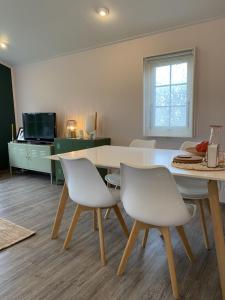une salle à manger avec une table et des chaises blanches dans l'établissement RBR 711 - Beach Resort Kamperland, à Kamperland