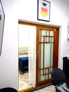 um quarto com uma porta de vidro num quarto em Flat Duplo para sua conexão em Guarulhos