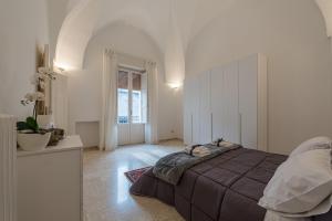 1 dormitorio con 1 cama grande en una habitación blanca en Dimora Cece, en Francavilla Fontana