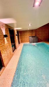 a large swimming pool in a room with a brick wall at Family House in Cagayan de Oro City in Cagayan de Oro