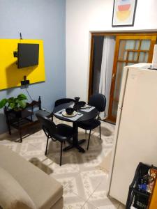 uma sala de estar com uma mesa e cadeiras e uma televisão em Flat Duplo para sua conexão em Guarulhos
