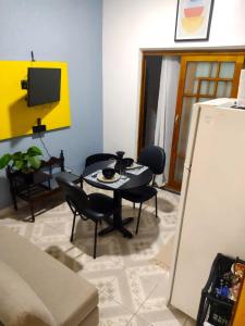 a living room with a table and chairs and a tv at Flat Duplo para sua conexão in Guarulhos
