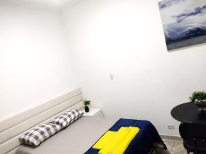 a bedroom with a bed with a yellow and blue blanket at Flat Duplo para sua conexão in Guarulhos