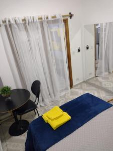 um quarto com uma cama com uma toalha amarela em Flat Duplo para sua conexão em Guarulhos