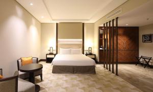 ジッダにあるAerotel Jeddahのベッド、テーブル、椅子が備わるホテルルームです。