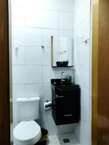 a bathroom with a toilet and a sink and a mirror at Flat Duplo para sua conexão in Guarulhos