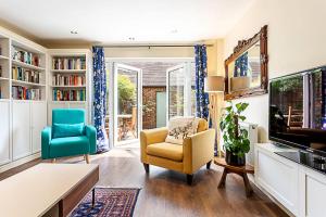 sala de estar con TV y 2 sillas en Terraced Bermondsey House en Londres