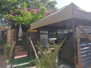 a patio with an umbrella and a table and chairs at Xenia Bed & Breakfast in Windhoek