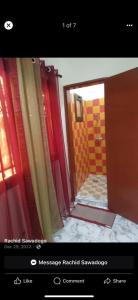 a bathroom with a mirror and a red and yellow shower at Sawadogo meublée in Ouagadougou