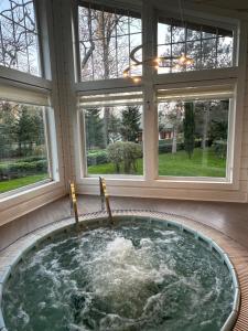 a jacuzzi tub in a room with windows at RIVER INN RESORT AND SPA in Nabran