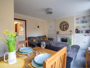 a living room with a table and a couch at Bumble Cottage in Chipping Campden