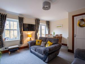 a living room with a couch and a table at Bumble Cottage in Chipping Campden