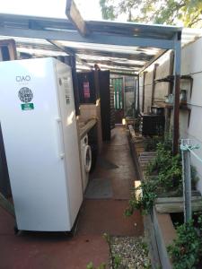 a white refrigerator sitting in a garage next to a house at Xenia Bed & Breakfast in Windhoek