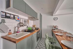 a small kitchen with a sink and a counter at La Cigale - Vieux Village - Charmante Maisonnette climatisée avec Jardin in Villeneuve-lès-Avignon