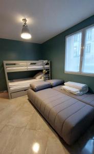 1 dormitorio con 2 camas y 1 litera en Rez-de-chaussée de plain-pied avec parking privé au centre ville en Dieppe