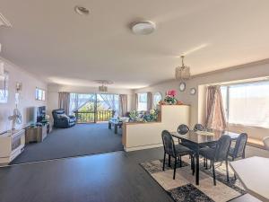 a living room with a table and a dining room at Available Now! Family home near Redwood Forest in Rotorua