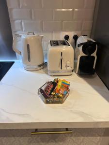 eine Küchentheke mit einem Toaster und einem Tablett mit Snacks in der Unterkunft Rosny01 Luxueux Gare Disney Paris in Rosny-sous-Bois