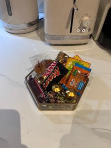 ein Paket mit Lebensmitteln und Süßigkeiten auf der Theke in der Unterkunft Rosny01 Luxueux Gare Disney Paris in Rosny-sous-Bois