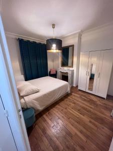 ein Schlafzimmer mit einem weißen Bett und einem blauen Vorhang in der Unterkunft Rosny01 Luxueux Gare Disney Paris in Rosny-sous-Bois