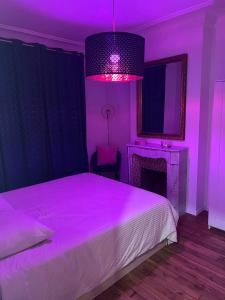 Schlafzimmer mit einem Bett mit lila Beleuchtung in der Unterkunft Rosny01 Luxueux Gare Disney Paris in Rosny-sous-Bois