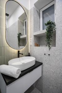 een badkamer met een witte wastafel en een spiegel bij K27- Boutique Apartments, Best Location, by BQA in Boedapest