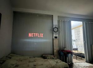 ein Schlafzimmer mit einem Bett mit einem Netflix-Schild an der Wand in der Unterkunft Stay with Adem in Skopje