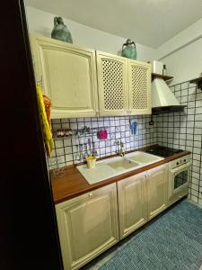 eine Küche mit weißen Schränken und einem Waschbecken in der Unterkunft Residence Horizonte Roccaraso in Roccaraso