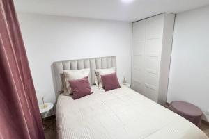 ein Schlafzimmer mit einem großen weißen Bett mit zwei Kissen in der Unterkunft Bondy16 Gare Paris Disney in Bondy