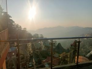 a view of a city from a balcony with the sun at zoz Sm1 in Shimla