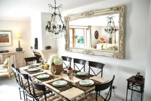 jadalnia ze stołem, krzesłami i lustrem w obiekcie Stunning Mountain Views with Secluded Private Pool w mieście La Roquette-sur-Var