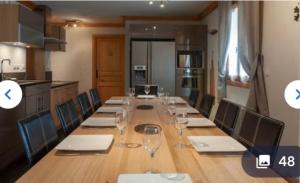 a long table with chairs and wine glasses on it at Chalet 12 personnes st martin de Belleville 3 vallées in Béranger +11 photos