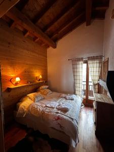 une chambre avec un lit dans une pièce aux murs en bois dans l'établissement Grand Chalet Éden 12 personnes st martin de Belleville 3 vallées, à Béranger